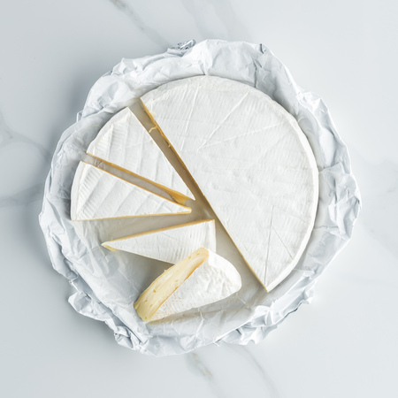 top view of camembert cheese on white marble tabletop