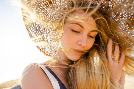 portrait of beautiful pensive woman in straw hat looking awayの写真素材