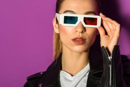 beautiful young asian woman in 3d glasses looking at camera isolated on violet