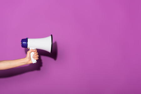 cropped image of woman holding megaphone on purple backgroundの写真素材