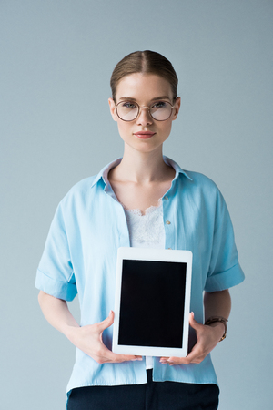 beautiful young woman holding tablet with blank screen isolated on whiteの写真素材