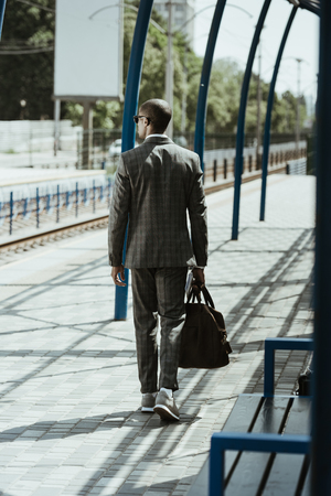 Businessman in stylish suit walking on public transport stationの写真素材