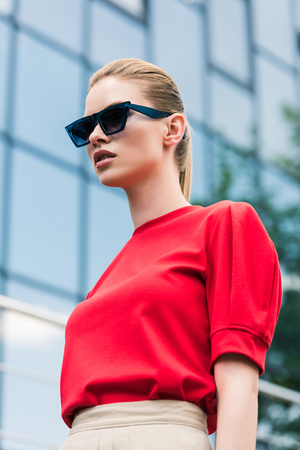 low angle view of stylish young female model in sunglassesの写真素材
