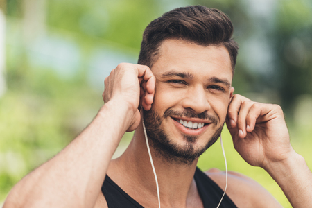 portrait of young man listening music with earphonesの写真素材