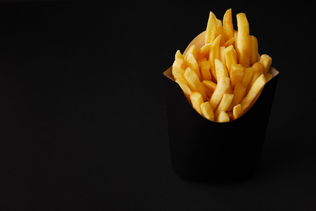 black box of tasty french fries isolated on black isolated on blackの写真素材