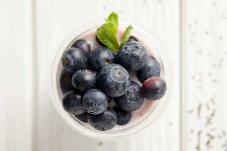 Top view of pudding with blueberries and mint on white wooden surfaceの写真素材