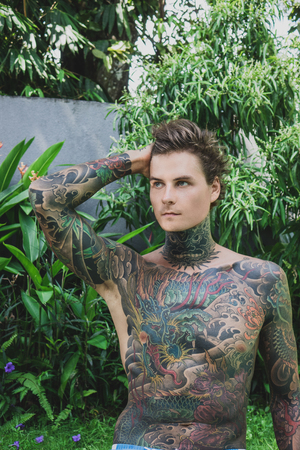 portrait of pensive tattooed young man looking away, bali, indonesiaの写真素材