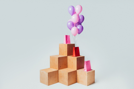 shopping bags with bundle of pink and violet balloons isolated on white, summer sale conceptの写真素材