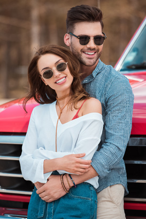 young beautiful couple hugging at red carの写真素材