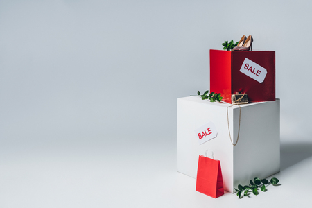 twigs with green leaves, high heels and sale signs on cubes, summer sale conceptの写真素材