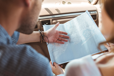 cropped view of travelers looking at map inside the carの写真素材