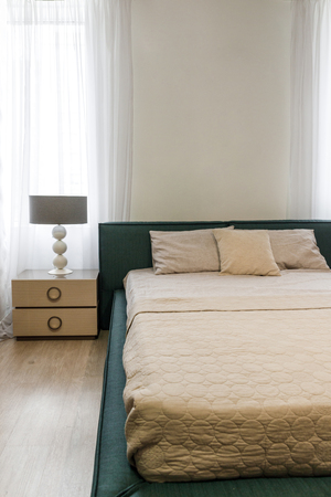 Light bedclothes on bed in cozy bedroomの写真素材
