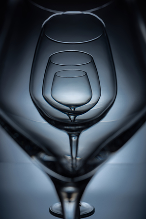 row of empty transparent wine glasses on greyの写真素材