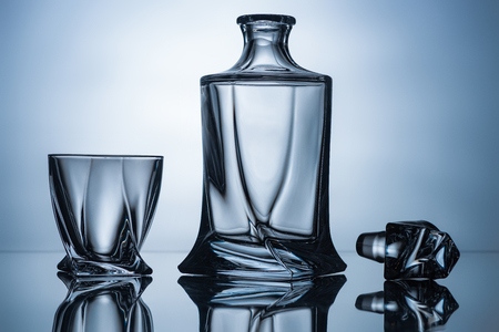 cognac glass and empty bottle on grey with reflectionsの写真素材