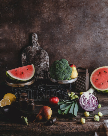 cutting board, grater, scales, different fruits and vegetables on rustic wooden tabletopの写真素材
