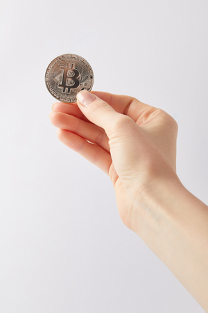 cropped shot of woman holding silver bitcoin isolated on whiteの写真素材