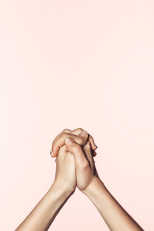 cropped shot of woman holding own hands together isolated on pink backgroundの写真素材