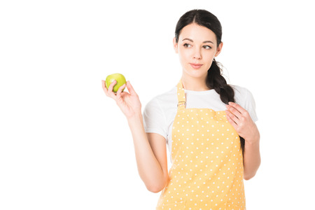 attractive woman in apron holding apple in hand isolated on white backgroundの写真素材