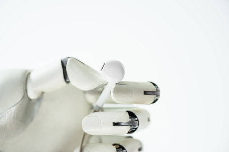 close-up view of robot holding earphone isolated on whiteの写真素材