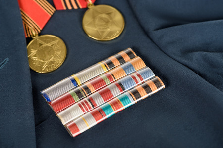 closeup shot of different medals on navy blue jacket, victory day conceptの写真素材