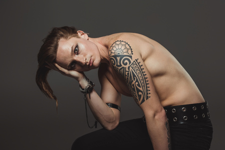 shirtless man with tattoo and strange hairstyle, isolated on greyの写真素材