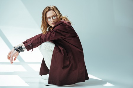 stylish man posing in trench coat, on greyの写真素材