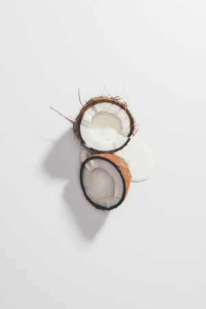 top view of halved organic tasty coconut on whiteの写真素材