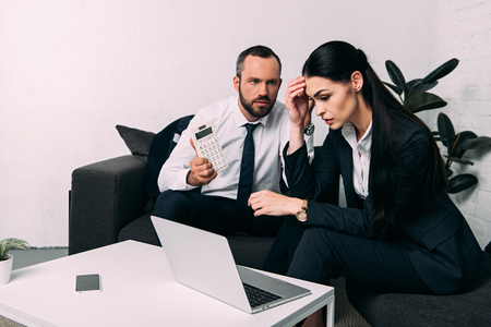 stressed business colleagues working together at coffee table in officeの写真素材