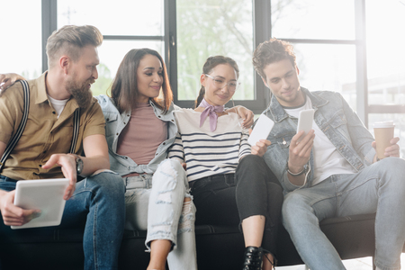 Diverse business team looking at smartphone screen in light workspace