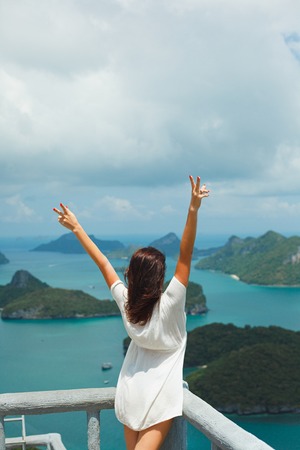 back view of woman standing with hands up at Ang Thong National Park, Ko Samui, Thailandの写真素材