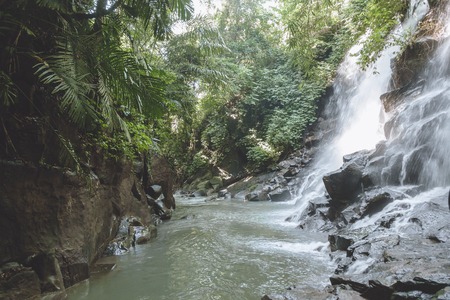 scenic view of beautiful Kanto Lampo Waterfall, green plants and rocks, Bali, Indonesiaの写真素材