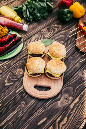 Cut vegetables and burgers grilled for outdoors barbecueの写真素材