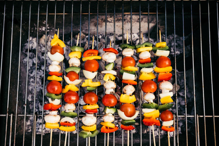 Top view of seasonal vegetables and mushrooms on skewers grilled for outdoors barbecueの写真素材