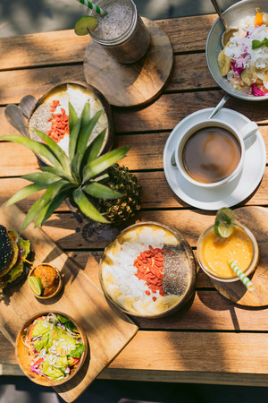 top view of pineapple, delicious tropical cocktails and snacks on wooden tableの写真素材