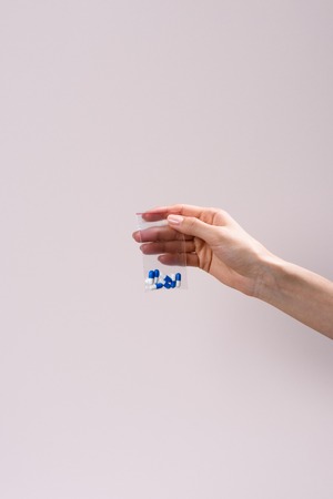 cropped shot of woman holding zip bag with pills isolated on greyの写真素材