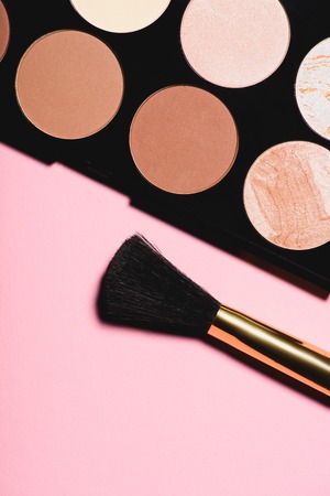top view of various blushes palette with brush on pink surfaceの写真素材