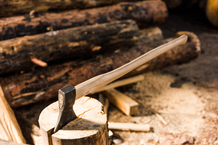 close up view of sticking axe in log at sawmill
