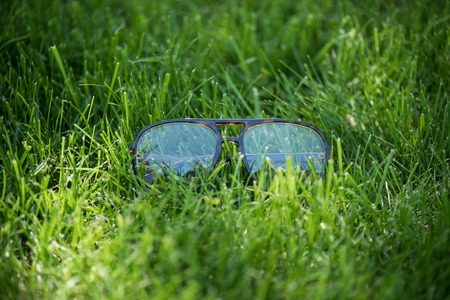 close up view of eyeglasses on green lawnの写真素材