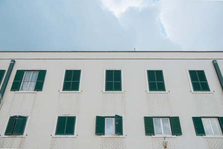 bottom view of european building with shuttered windows in front of cloudy sky, Anzio, Italyの写真素材