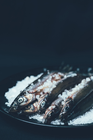 Pile of salted fish in frying pan isolated on blackの写真素材