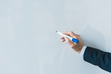 cropped shot of businessman writing on blank whiteboardの写真素材