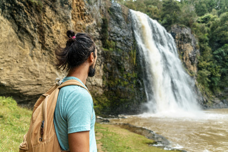 young bearded man looking at waterfall, Hunua Falls, New Zealandの写真素材