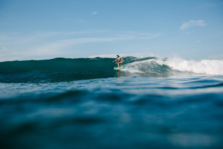 handsome man riding waves on surfboard while having vacation