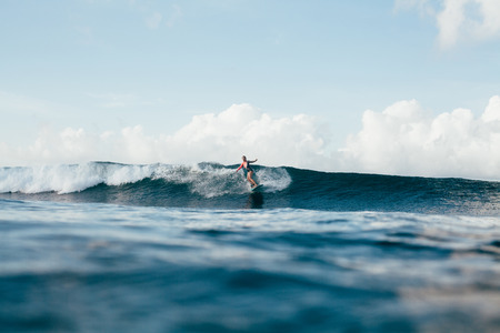 young sportswoman in wetsuit surfing on sunny dayの写真素材