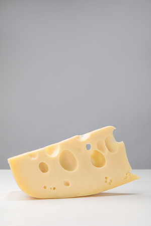 Close up image of maasdam cheese on grayの写真素材