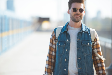 stylish male tourist in sunglasses with backpack at outdoor subway stationの写真素材