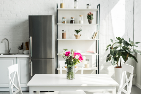 interior of modern light kitchen with bouquet of tulips on tableの写真素材