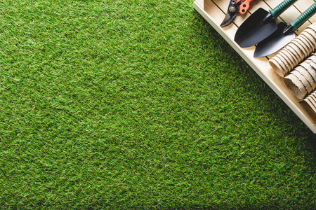 top view of stacks of flower pots and gardening tools on grassの写真素材