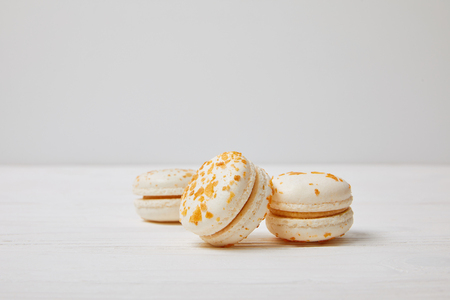 closeup shot of three macarons on white wooden tableの写真素材