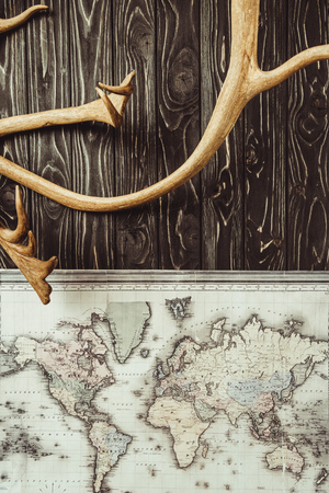 top view of decorative horns with map on dark wooden tabletopの写真素材